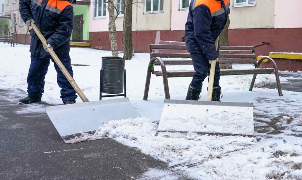 GARANT Winterdienst Gebaeudereiniger räumen den Weg frei mit Schneeschaufeln